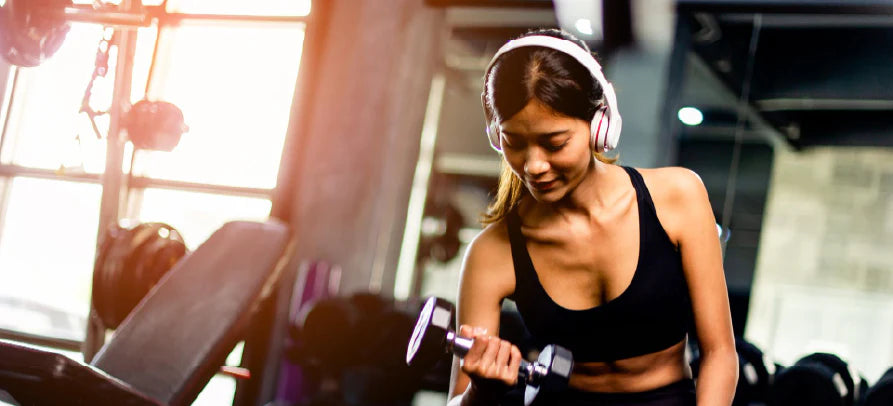 Mulher em treino de força, transmitindo foco, energia e compromisso com o desempenho físico.