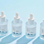 Frasco da 1025 Dokdo Ampola 200ml da Round Lab, tratamento intensivo para hidratação profunda e fortalecimento da barreira cutânea.